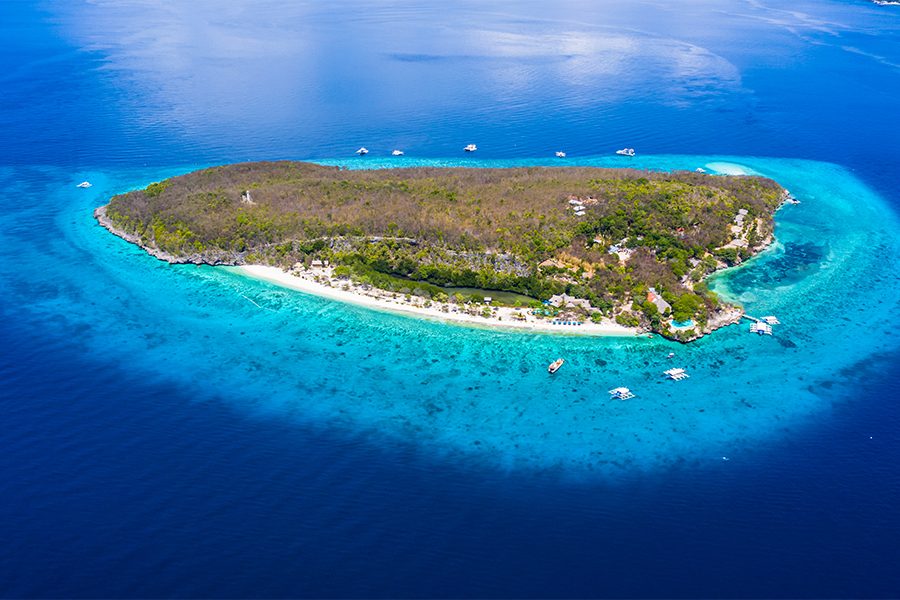 Sumilon Beach from afar, surrounded by deep blue water